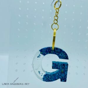 Nøkkelring G, turkis glitter